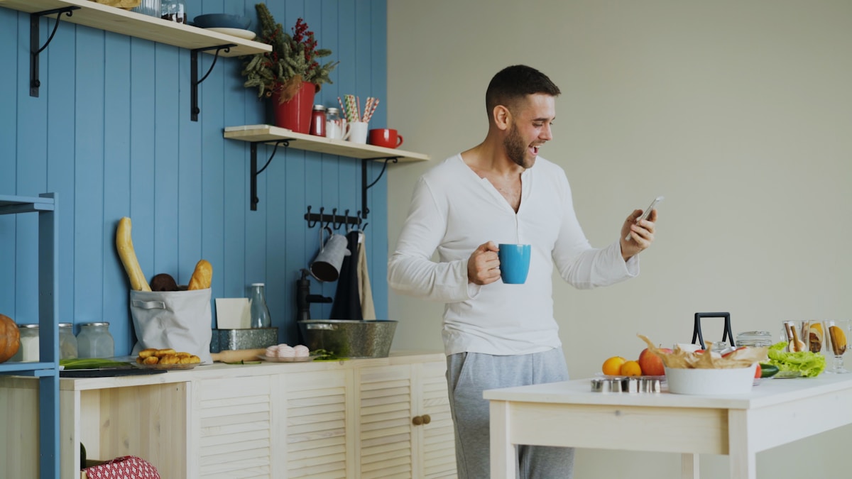 Man checking his phone over morning coffee